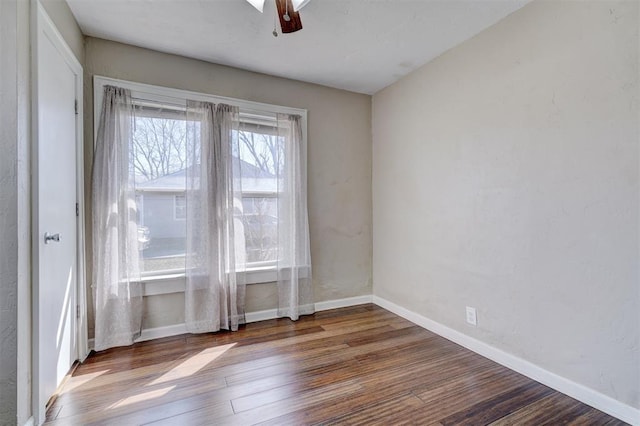 spare room with a ceiling fan, baseboards, and wood finished floors