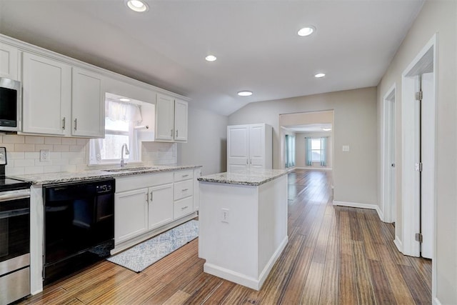 kitchen with a sink, wood finished floors, white cabinetry, and stainless steel appliances