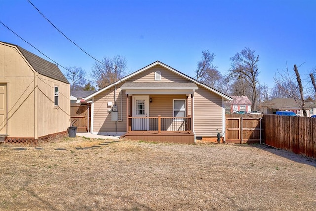 rear view of house with crawl space, a porch, a gate, and fence