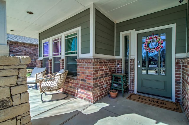 property entrance featuring brick siding and a porch