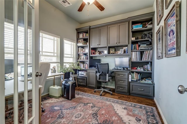 home office with visible vents, a ceiling fan, dark wood finished floors, french doors, and baseboards