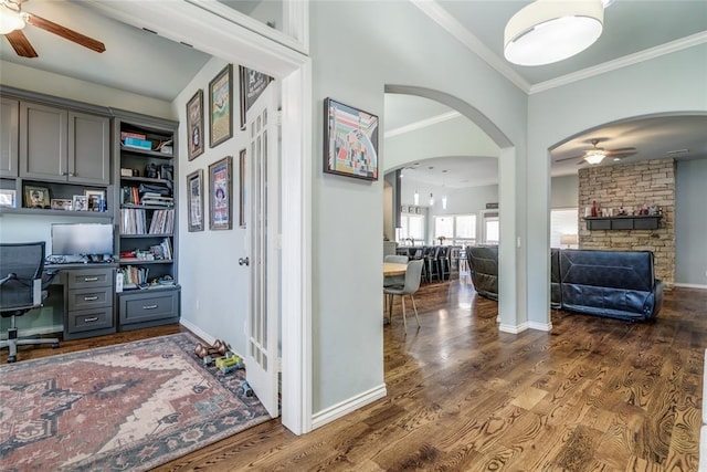 office area with ceiling fan, wood finished floors, built in desk, and crown molding