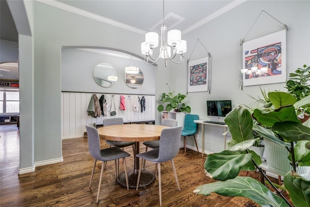 dining room with visible vents, a notable chandelier, ornamental molding, wood finished floors, and baseboards