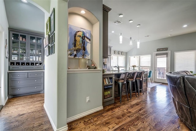 interior space with baseboards, visible vents, lofted ceiling, recessed lighting, and dark wood-type flooring