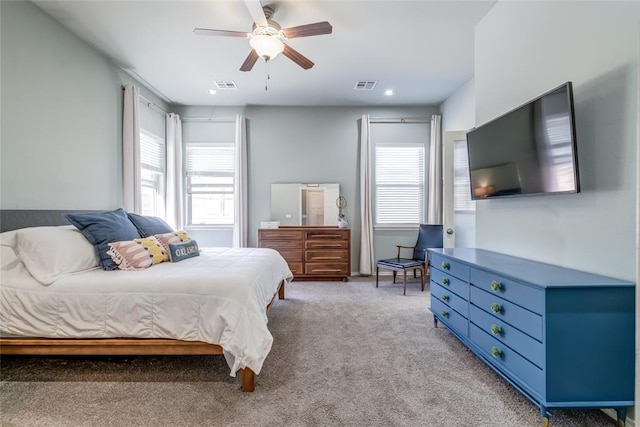 bedroom with multiple windows, visible vents, and light carpet