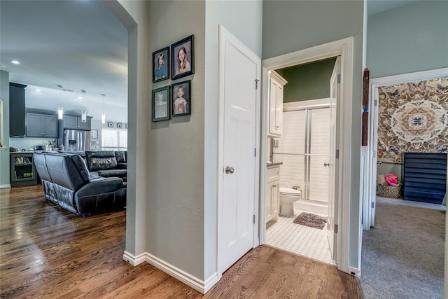 hallway featuring dark wood finished floors and baseboards