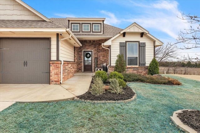 view of front facade with roof with shingles, an attached garage, a front lawn, concrete driveway, and brick siding