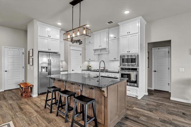 kitchen with tasteful backsplash, visible vents, appliances with stainless steel finishes, and dark wood-type flooring