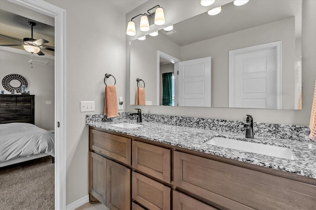 full bathroom with a sink, ensuite bathroom, ceiling fan, and double vanity