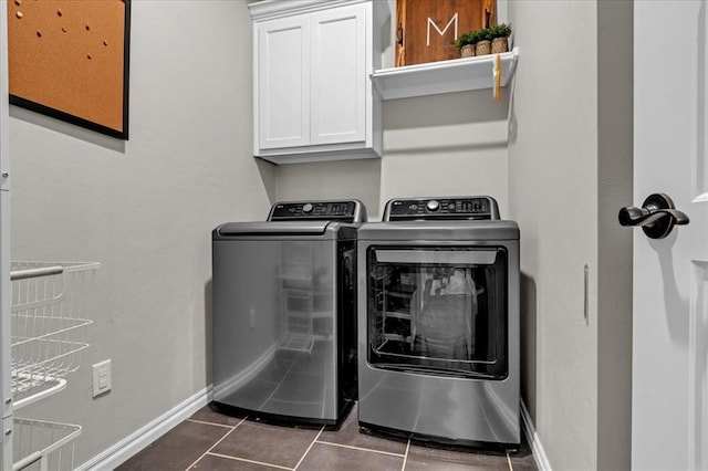 laundry area featuring baseboards, cabinet space, independent washer and dryer, and dark tile patterned floors