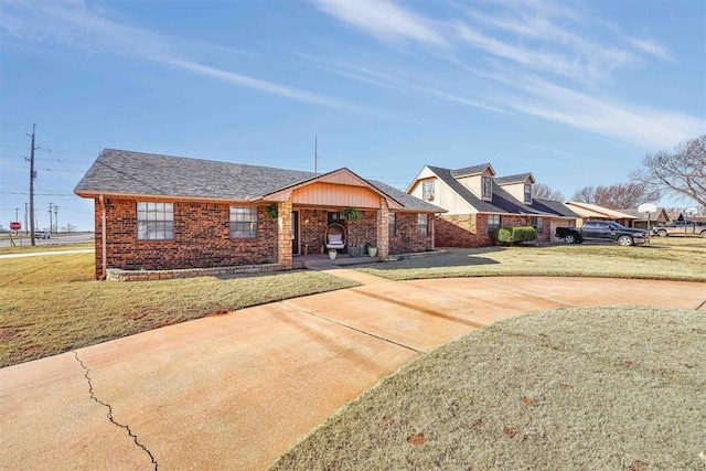 view of front of house with brick siding, concrete driveway, and a front yard