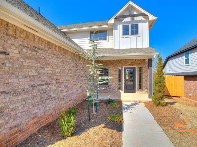 doorway to property featuring brick siding and board and batten siding