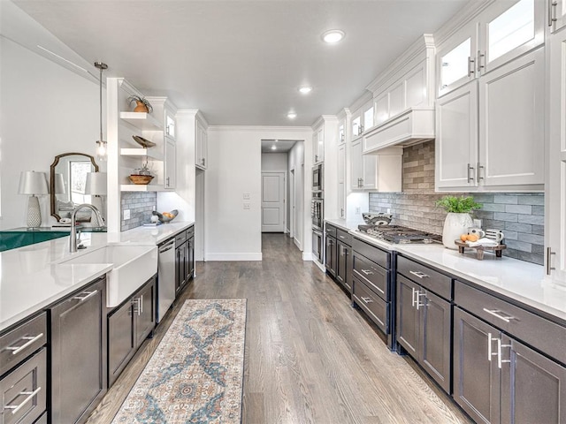 kitchen featuring white cabinets, stainless steel appliances, light countertops, and a sink