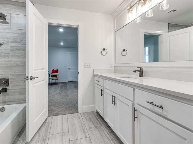 full bath with vanity, visible vents, baseboards, and shower / bath combination