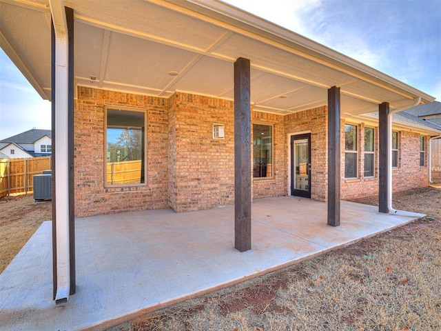 view of patio with central AC unit and fence