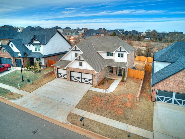 view of front of home featuring fence, roof with shingles, concrete driveway, board and batten siding, and a residential view