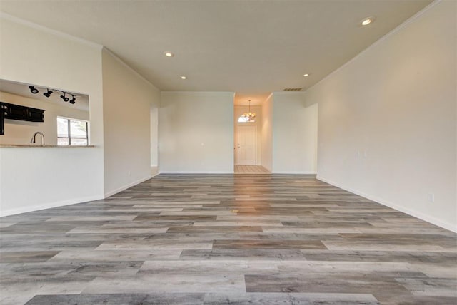 unfurnished room featuring recessed lighting, baseboards, wood finished floors, and crown molding