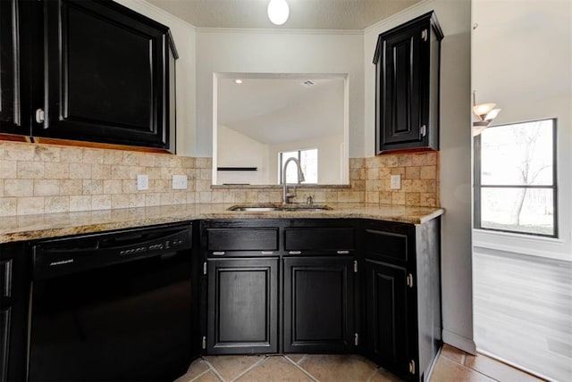 kitchen featuring light stone counters, a sink, dishwasher, dark cabinets, and backsplash