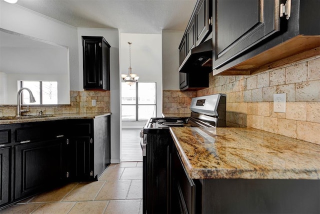 kitchen with under cabinet range hood, electric range, dark cabinetry, and a sink