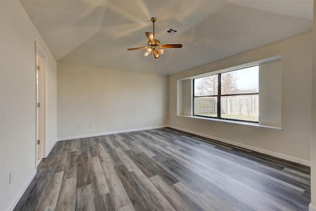 spare room with visible vents, dark wood-type flooring, ceiling fan, baseboards, and lofted ceiling