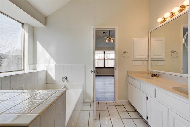 full bath with lofted ceiling, double vanity, a bath, tile patterned floors, and a sink