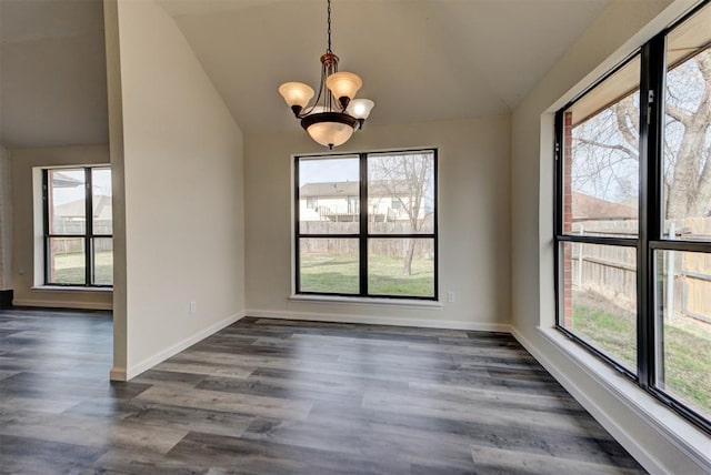 unfurnished dining area with baseboards, a notable chandelier, dark wood finished floors, and vaulted ceiling