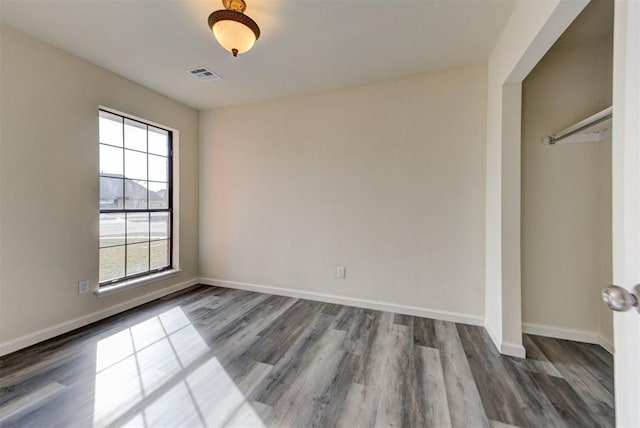 interior space featuring wood finished floors, visible vents, and baseboards