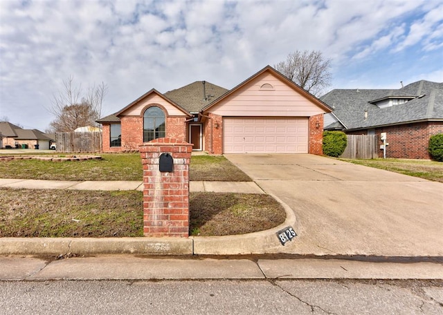 view of front of home with brick siding, an attached garage, driveway, and fence