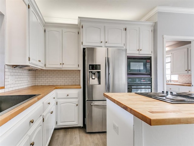 kitchen featuring butcher block countertops, black appliances, light wood-style floors, white cabinetry, and tasteful backsplash