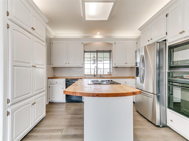 kitchen featuring light wood-style floors, black appliances, butcher block counters, and white cabinetry