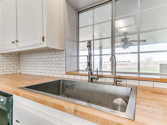 kitchen with dishwashing machine, plenty of natural light, wood counters, and a sink