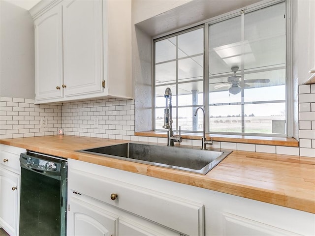 kitchen featuring a wealth of natural light, dishwasher, wood counters, and a sink