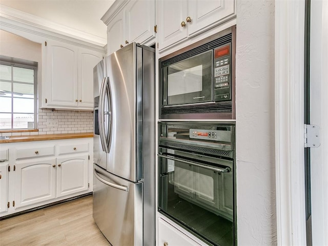 kitchen with black appliances, backsplash, white cabinetry, light wood-style floors, and a textured wall