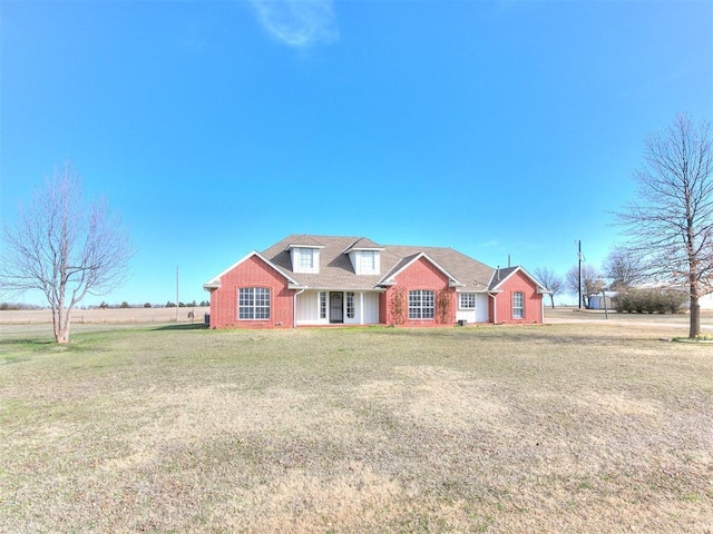 view of front of house with brick siding and a front lawn