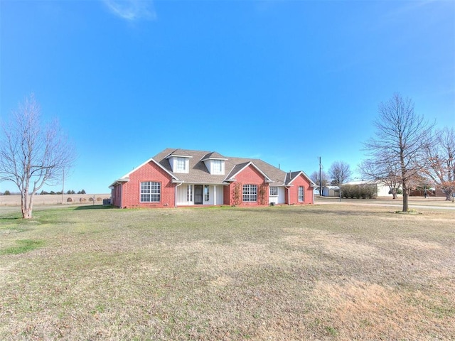 view of front of house with a front yard and brick siding