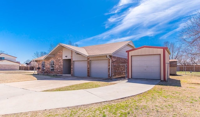 view of front of home with brick siding, a garage, and fence