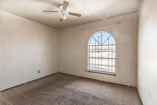 carpeted spare room with ceiling fan and a textured ceiling