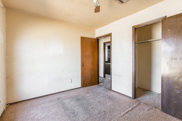 unfurnished bedroom featuring a textured ceiling, a closet, carpet flooring, baseboards, and ceiling fan