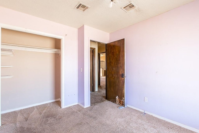 unfurnished bedroom featuring carpet flooring, visible vents, and a textured ceiling