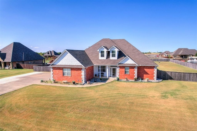 view of front of house with brick siding, a front yard, and fence