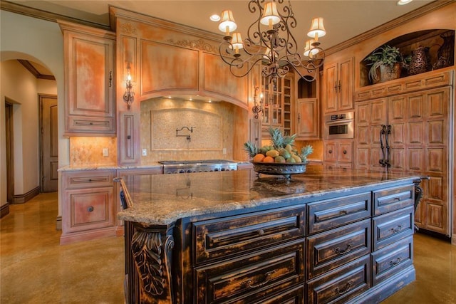 kitchen featuring stone countertops, stainless steel appliances, arched walkways, decorative backsplash, and a chandelier