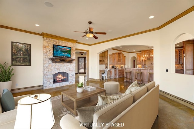 living room featuring baseboard heating, recessed lighting, a fireplace, arched walkways, and a ceiling fan