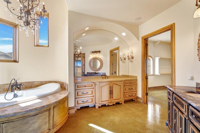 full bath featuring plenty of natural light, a sink, a garden tub, and two vanities