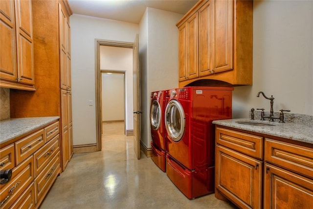 laundry room featuring separate washer and dryer, cabinet space, baseboards, and a sink