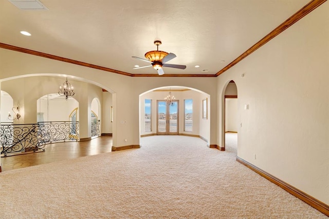 unfurnished living room with baseboards, carpet, arched walkways, and ceiling fan with notable chandelier