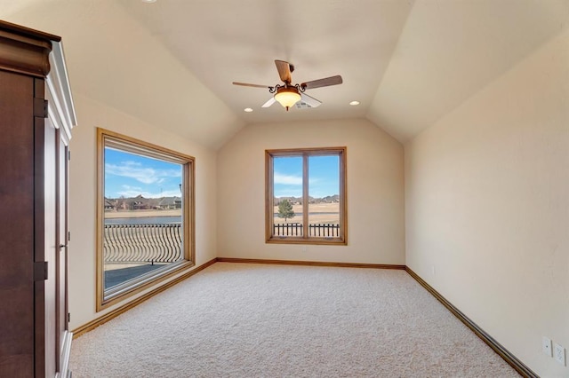 additional living space with baseboards, light carpet, a ceiling fan, and vaulted ceiling