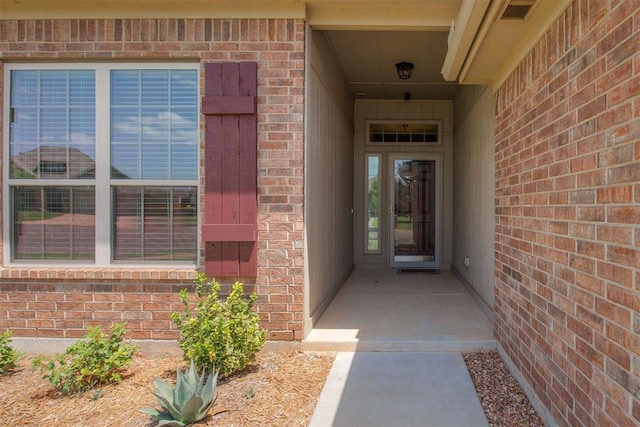 doorway to property with brick siding and visible vents