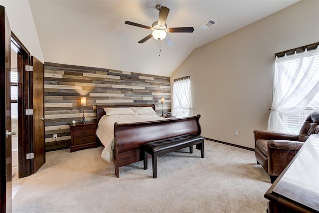 bedroom with visible vents, wooden walls, lofted ceiling, light colored carpet, and an accent wall