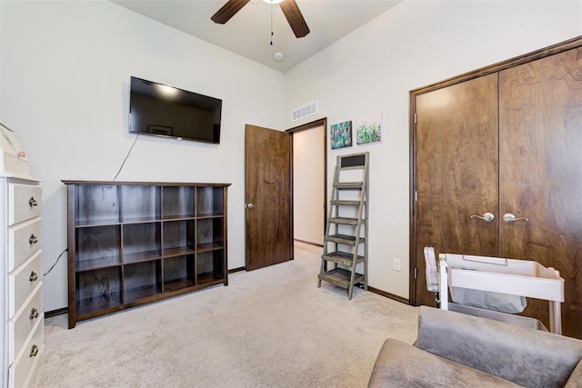 living area featuring visible vents, carpet flooring, baseboards, and a ceiling fan