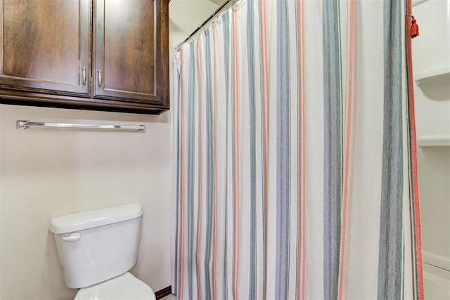 bathroom featuring toilet and a shower with shower curtain